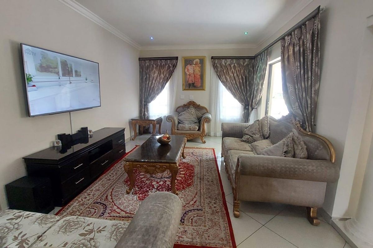 A well-maintained living room featuring tiled flooring, recessed downlighting, and decorative crown molding, providing a comfortable and functional space for relaxation.