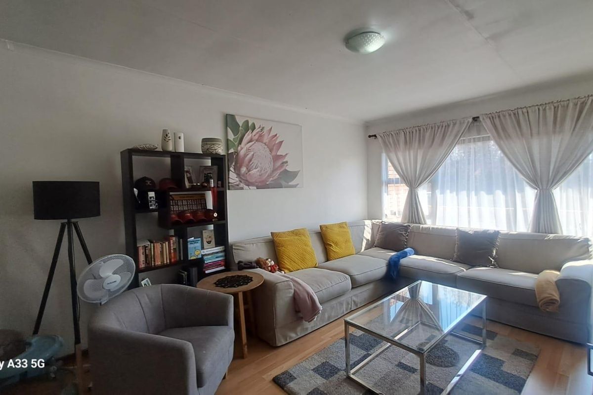 A comfortable living room featuring laminate flooring and a large sliding glass door that provides natural light.