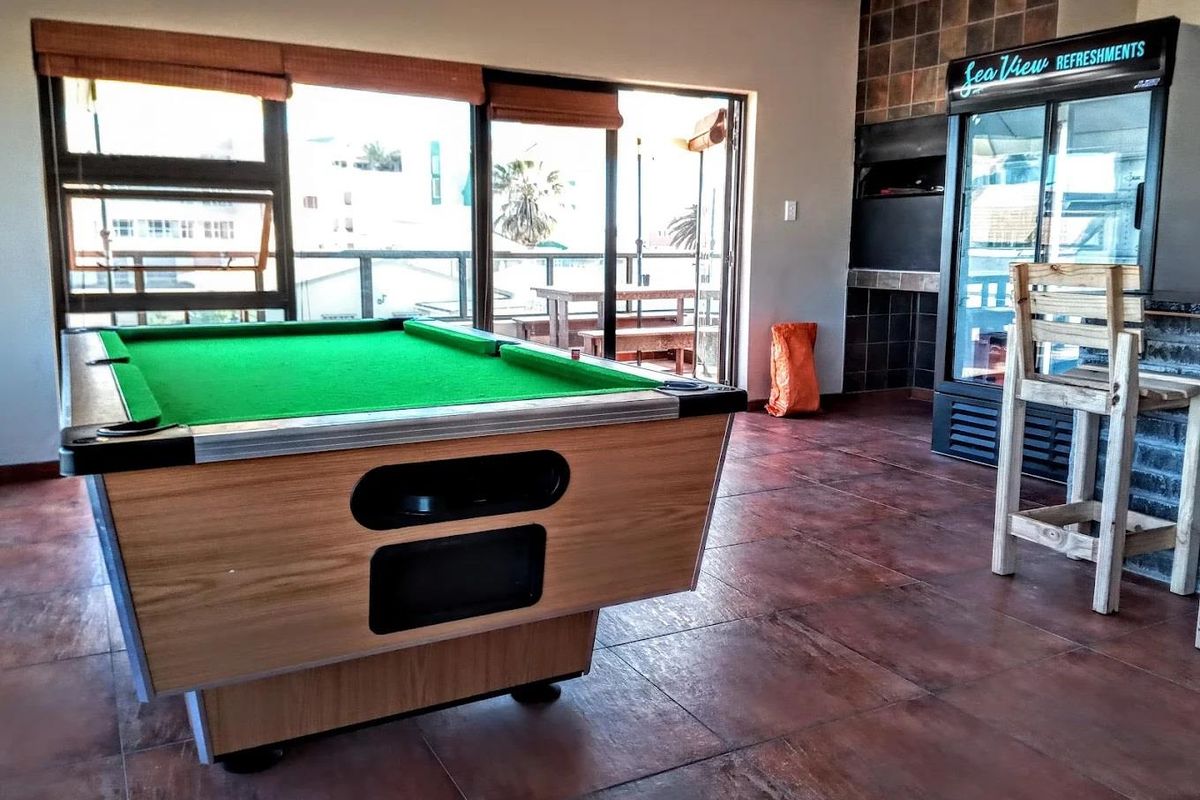 Entertainment area featuring a built-in braai, tiled flooring, and sliding doors opening onto a balcony with views.