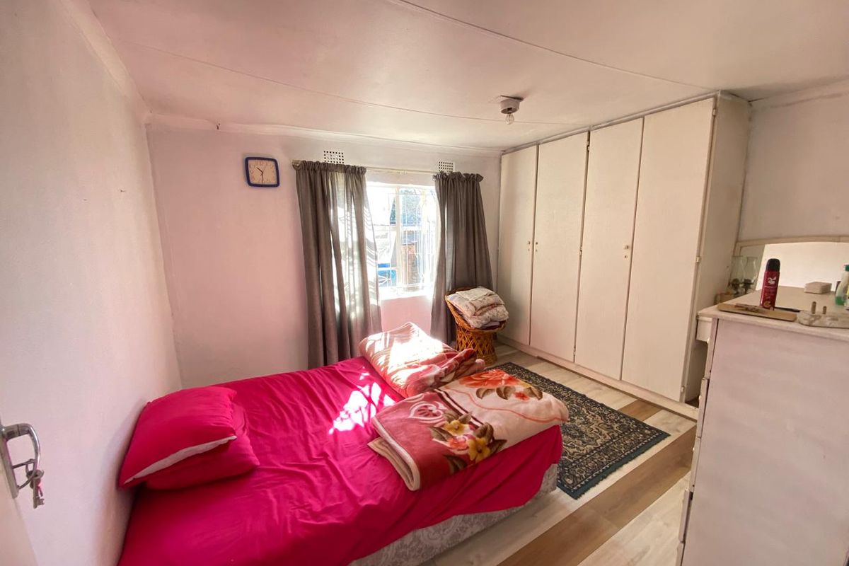 A bedroom featuring built-in wardrobes and laminate flooring, offering a functional space with potential for cosmetic updates.
