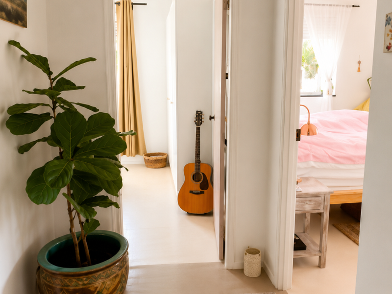 A bright, clean hallway providing access to adjacent bedrooms, featuring neutral flooring and well-maintained interior door frames.