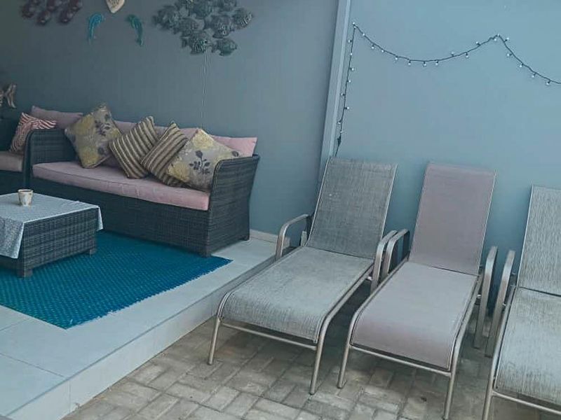 A covered outdoor patio area featuring a raised tiled platform and paved flooring, providing a functional space for outdoor relaxation.