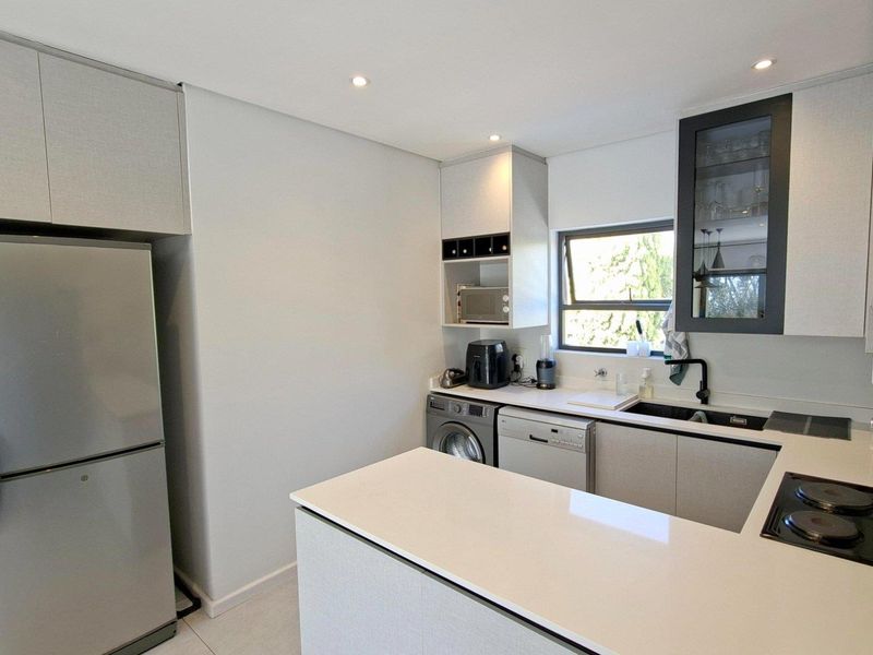 Modern kitchen featuring sleek cabinetry, quartz countertops, integrated hob, and high-quality finishes, offering a clean and functional culinary space.