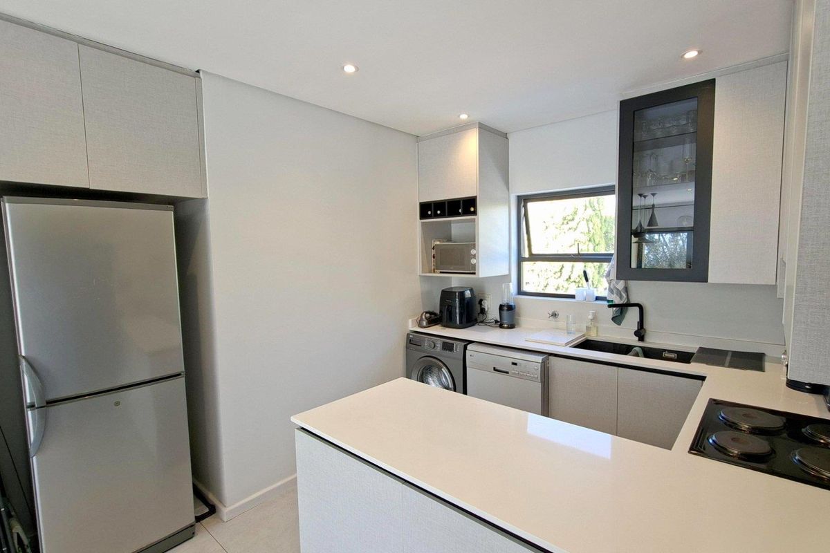 Modern kitchen featuring sleek cabinetry, quartz countertops, integrated hob, and high-quality finishes, offering a clean and functional culinary space.