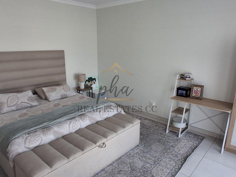 A well-maintained bedroom featuring neutral wall tones and tiled flooring, providing a clean and comfortable living space.