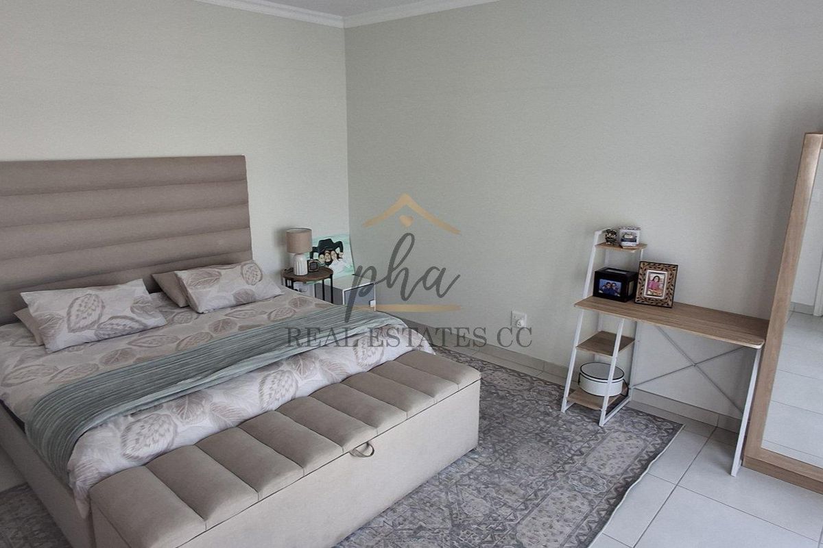 A well-maintained bedroom featuring neutral wall tones and tiled flooring, providing a clean and comfortable living space.
