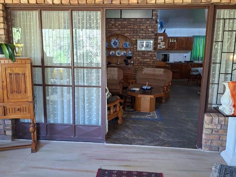 A covered patio area featuring exposed brick walls and large sliding glass doors that provide access to the interior living space.