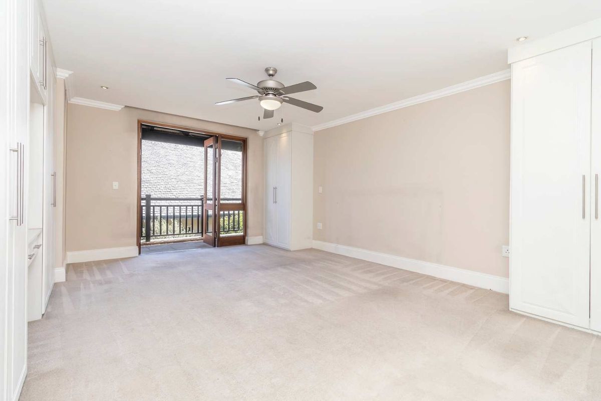 Spacious bedroom featuring neutral carpeting, built-in cabinetry, recessed lighting, and direct access to a private balcony.