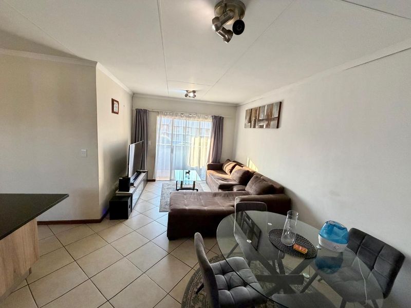 Open plan living and dining area featuring tiled flooring and a sliding glass door leading to an outdoor space.
