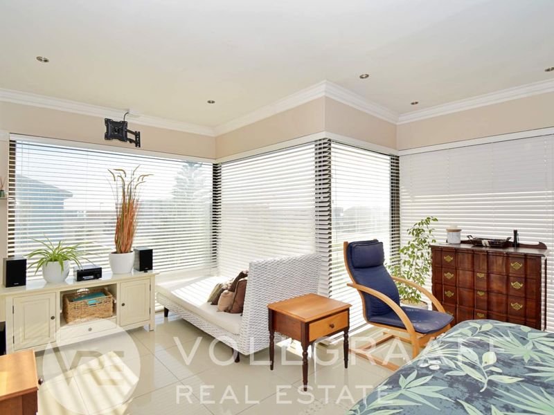 Bright bedroom featuring large corner windows with venetian blinds, tiled flooring, recessed downlighting, and decorative ceiling cornicing.