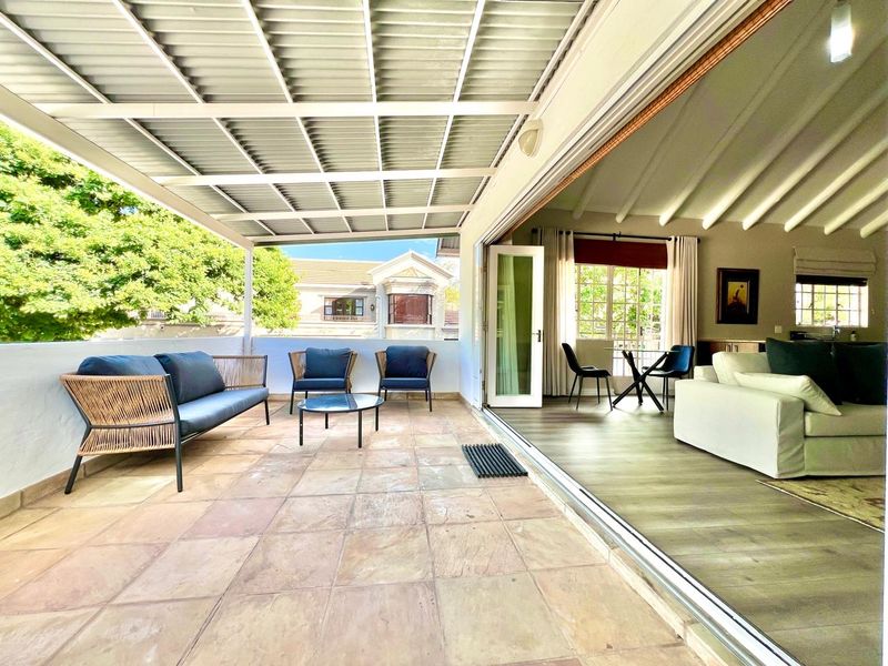 Spacious covered patio featuring tiled flooring and seamless indoor-outdoor flow through large sliding glass doors, perfect for entertaining.