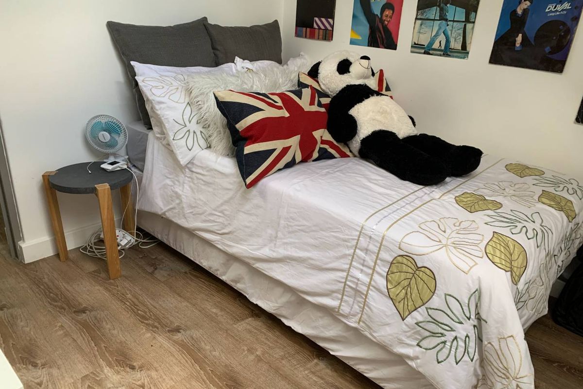 A cozy bedroom featuring durable laminate flooring and neutral wall finishes, providing a comfortable and functional sleeping space.