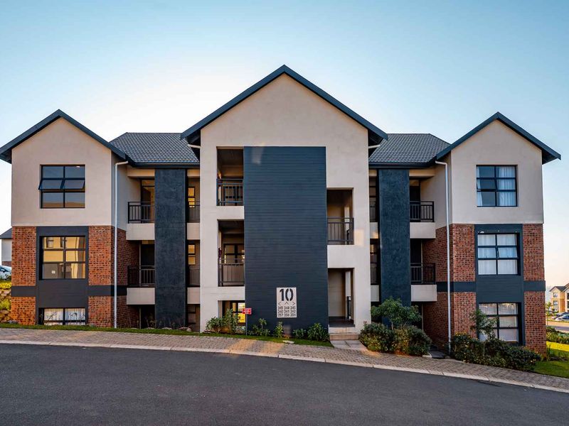 A modern multi-story apartment building featuring a combination of brick and rendered facade, tiled roofing, and private balconies.