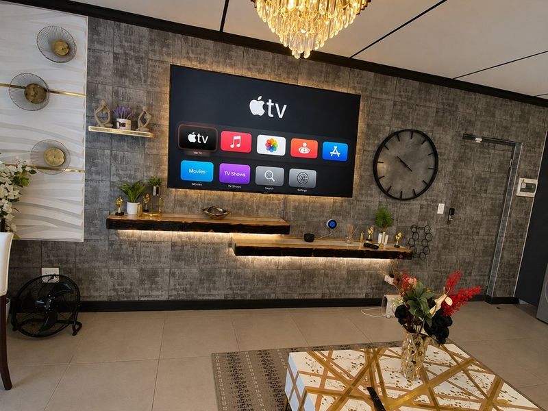Modern living room featuring a textured feature wall with integrated floating shelves, ambient LED lighting, and a sophisticated crystal chandelier.