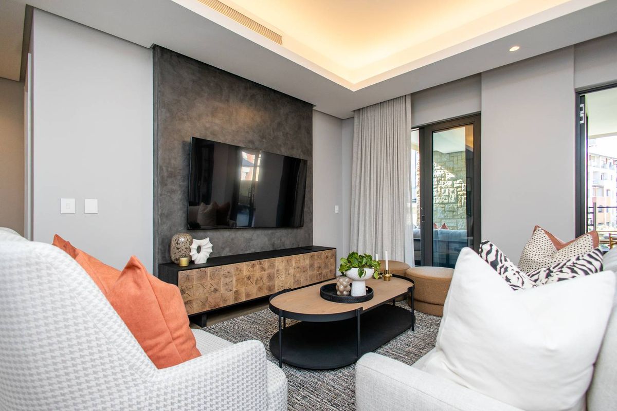 Modern living room featuring a textured feature wall, recessed ceiling lighting, and direct access to an outdoor balcony area.