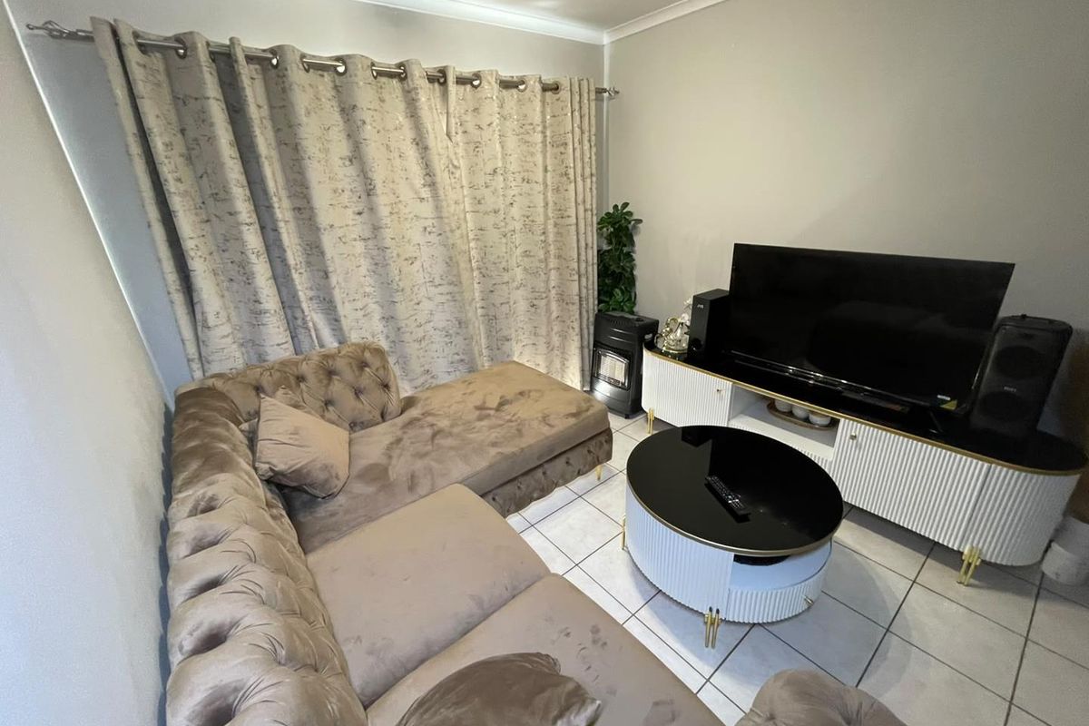 A living room featuring tiled flooring and neutral wall finishes, providing a functional space for relaxation.