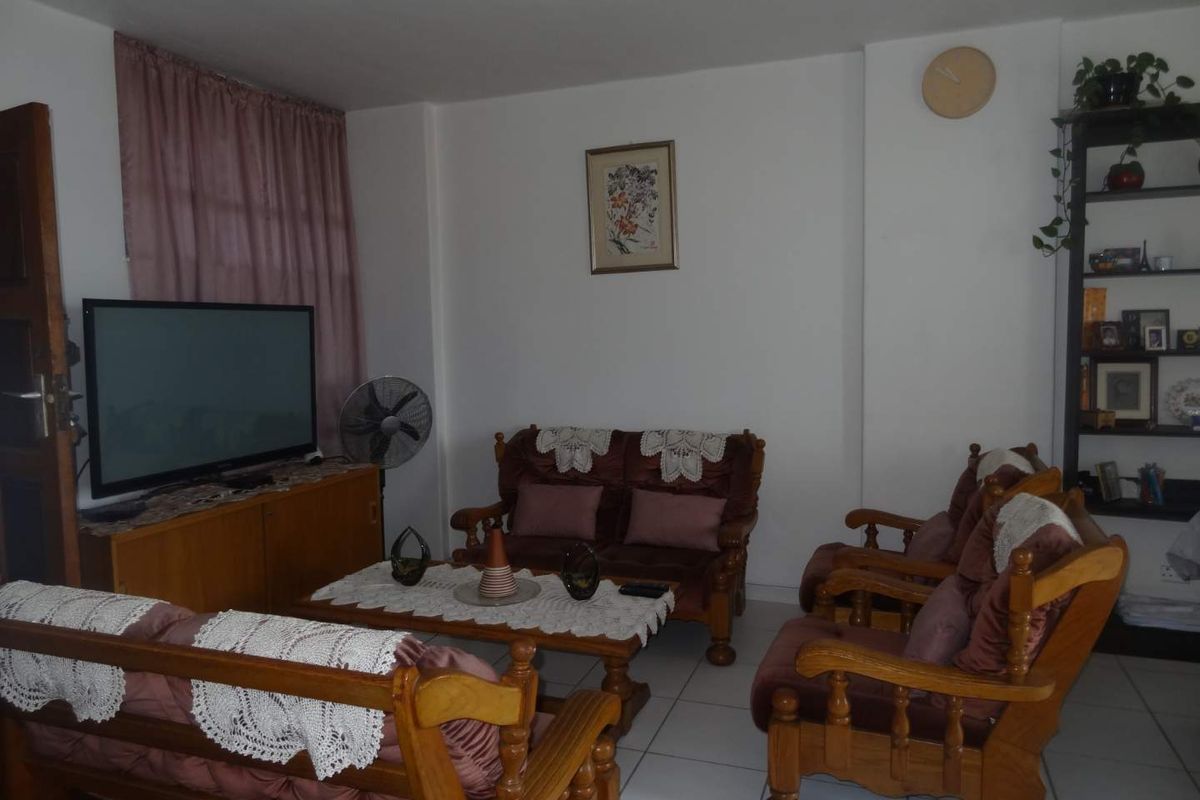 A living room featuring tiled flooring and neutral walls, providing a functional space for relaxation.