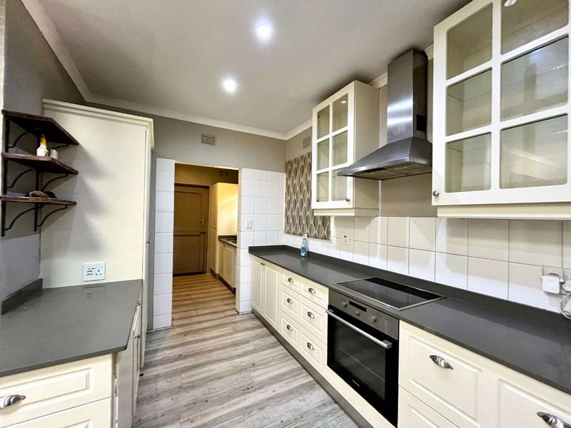 A well-maintained kitchen featuring modern cabinetry, stone countertops, integrated oven and cooktop, and a clean tiled backsplash with recessed lighting.