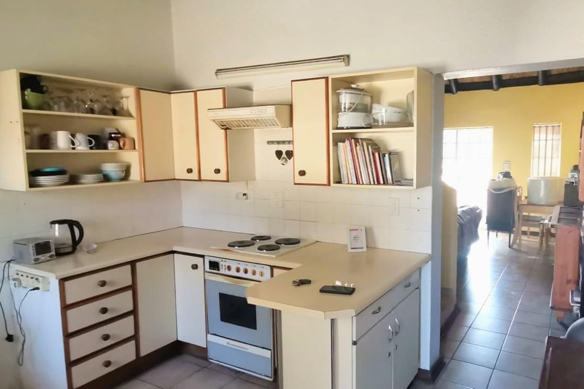 A functional kitchen featuring built-in cabinetry, laminate countertops, and an integrated electric stove, offering potential for modernization and aesthetic updates.
