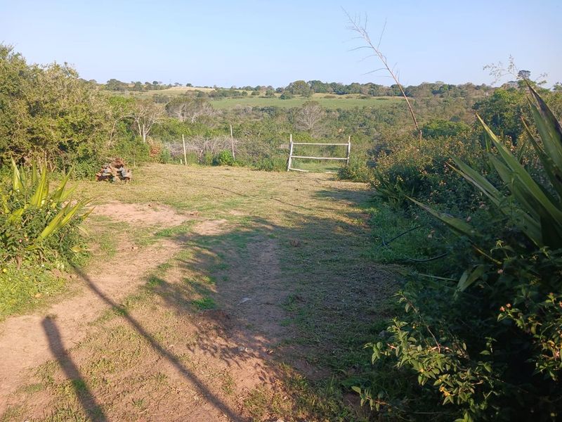 A view of the vacant residential land featuring natural vegetation and a simple wooden fence boundary overlooking the surrounding landscape.