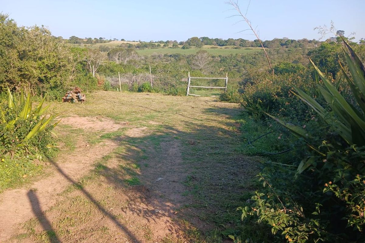 A view of the vacant residential land featuring natural vegetation and a simple wooden fence boundary overlooking the surrounding landscape.
