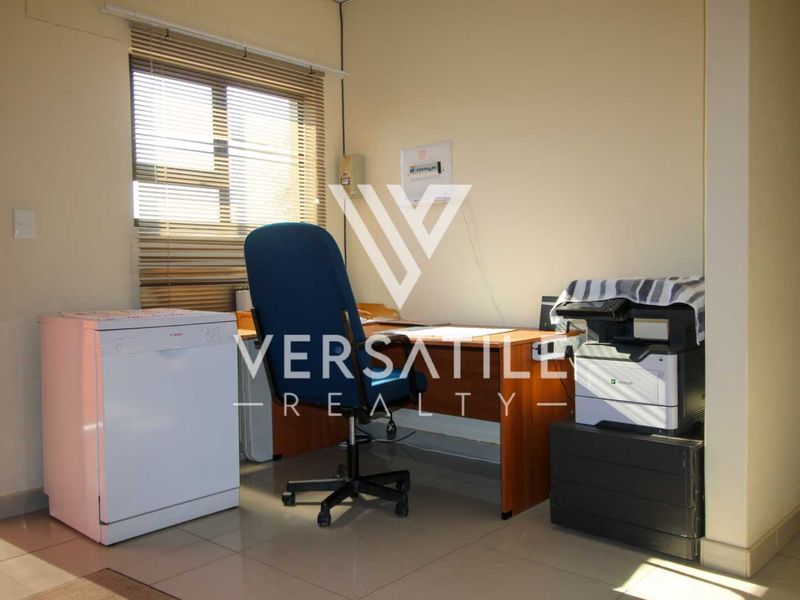 A functional office space featuring tiled flooring and venetian blinds, suitable for a home workspace or study area.