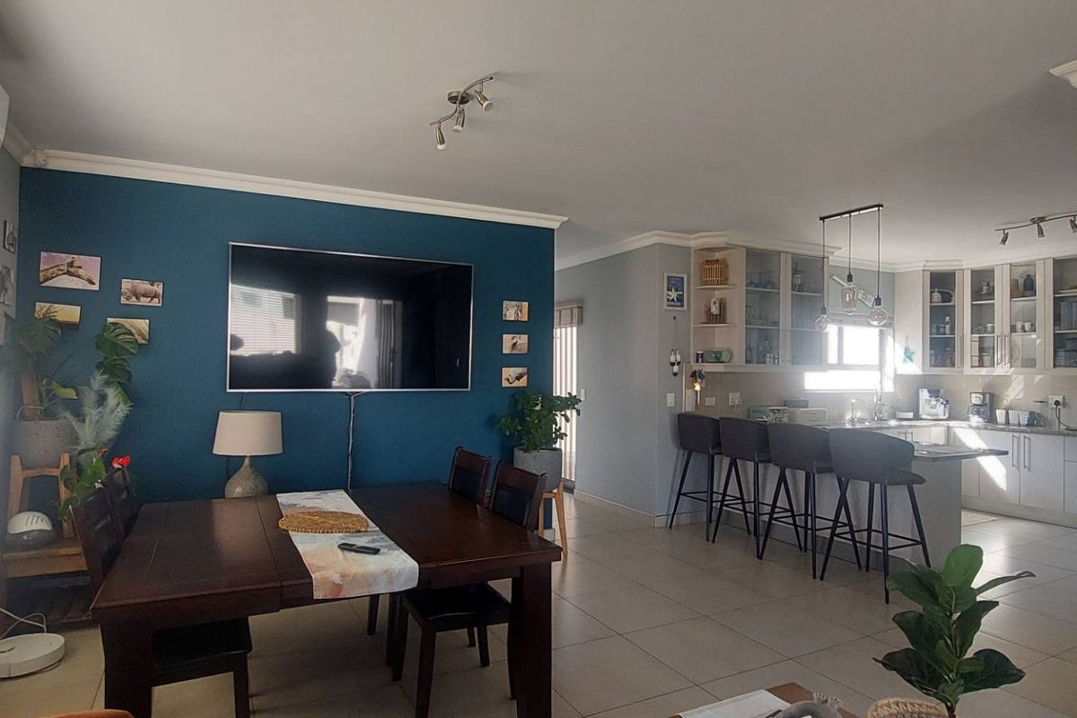 Spacious open-plan living and kitchen area featuring tiled floors, modern cabinetry, a central kitchen island, and split-system air conditioning.