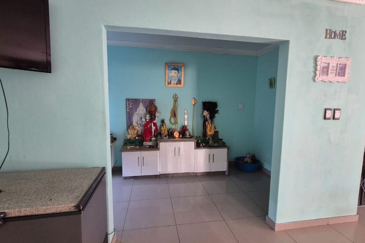 A living area featuring tiled flooring and a dedicated alcove space with built-in cabinetry, suitable for a prayer room or display area.