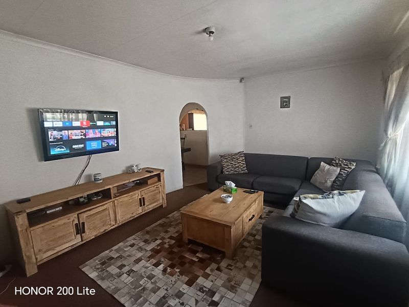 A comfortable living room featuring an arched doorway leading to an adjacent space and coved ceiling detailing.