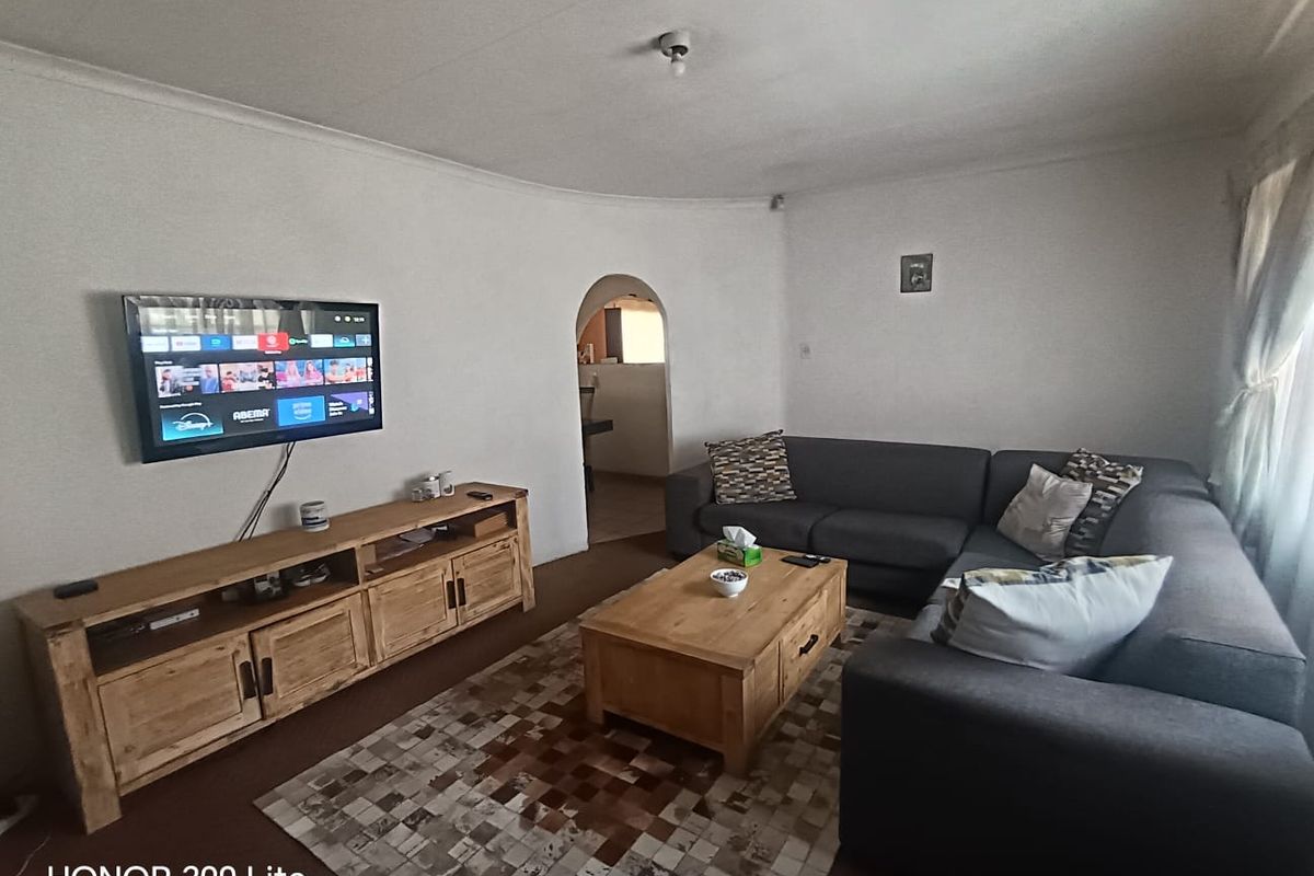 A comfortable living room featuring an arched doorway leading to an adjacent space and coved ceiling detailing.