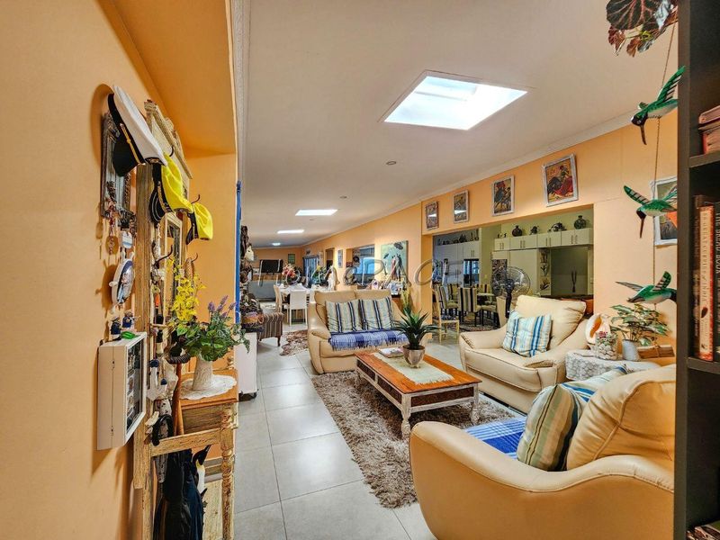 Spacious open-plan living and dining area featuring tiled flooring and multiple skylights, creating a bright and connected living environment.