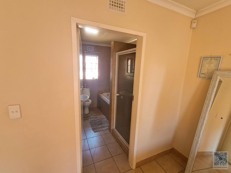 A functional bathroom featuring a shower enclosure, bathtub, and pedestal basin with tiled flooring and neutral wall finishes.