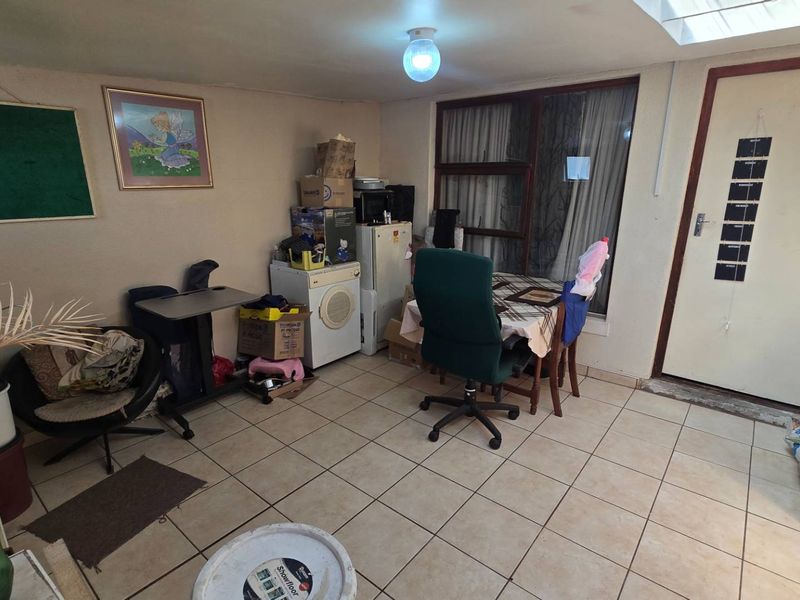 A functional living area featuring tiled flooring, a skylight for natural illumination, and direct access to the exterior.
