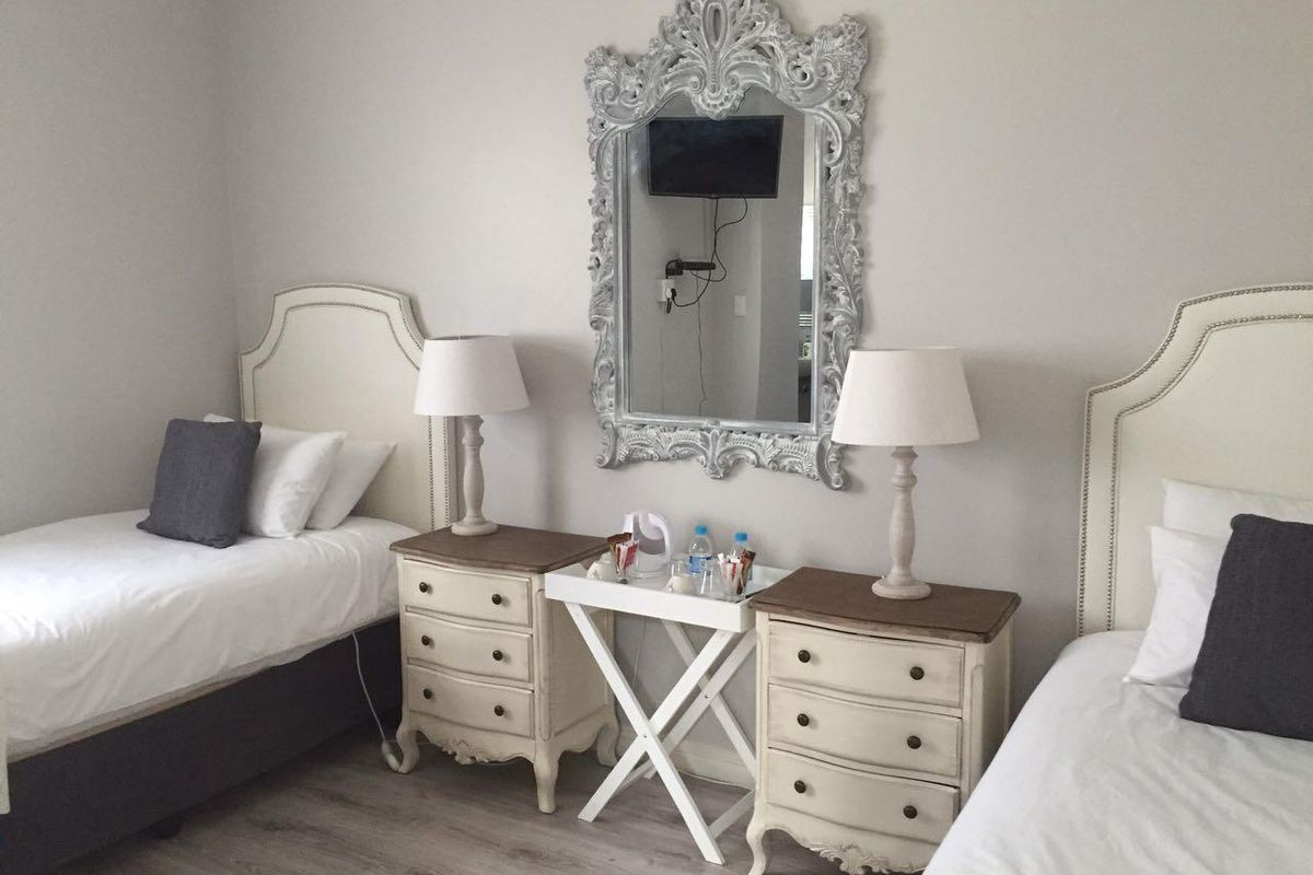 A well-maintained bedroom featuring light-toned laminate flooring and neutral wall finishes, providing a clean and comfortable sleeping space.