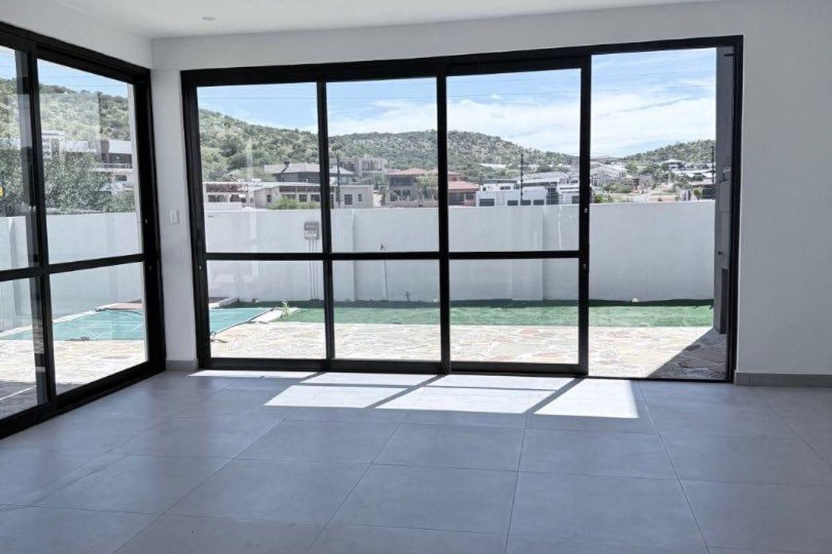 Bright and spacious living area featuring large sliding glass doors that provide seamless access to the outdoor patio and garden area.