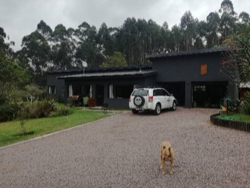 Front view of a single-story house featuring a gravel driveway, covered patio area, and an integrated double garage.