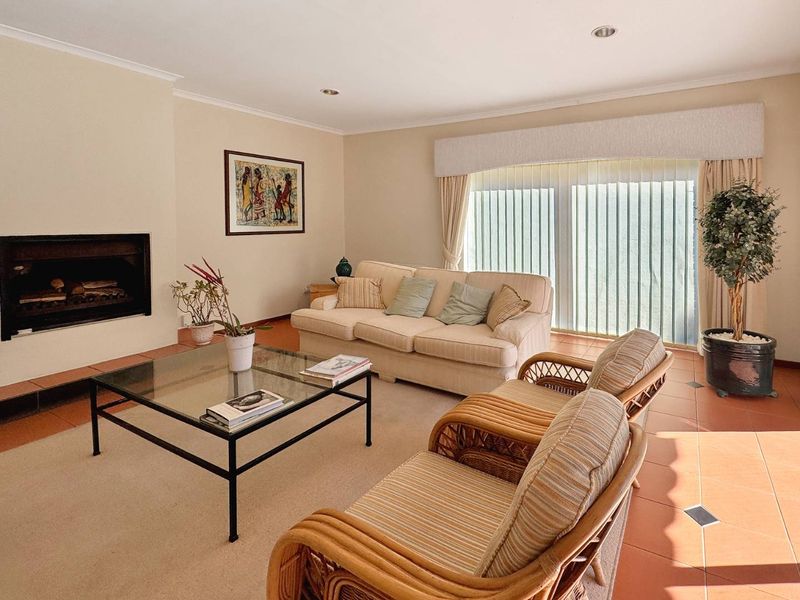 A comfortable living room featuring a built-in fireplace, tiled flooring, and large sliding glass doors that provide access to the outdoor area.
