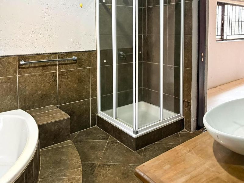 Bathroom featuring a tiled shower enclosure, built-in bathtub with tiled surround, and a vessel sink vanity.