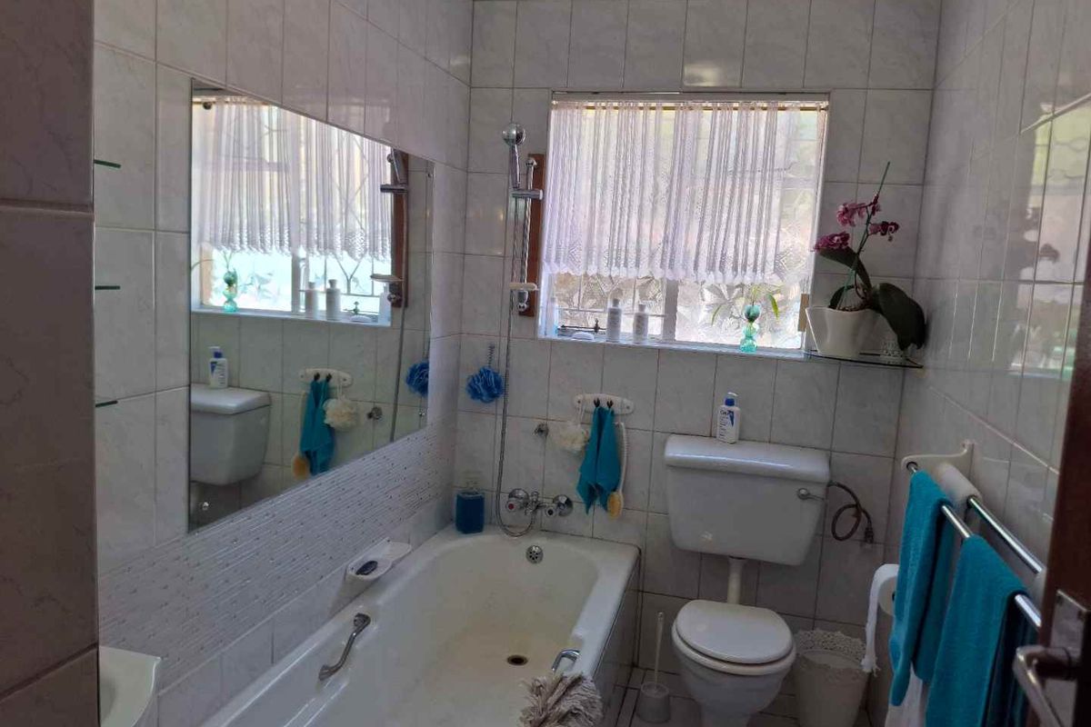 A functional bathroom featuring a bathtub, toilet, and tiled finishes, offering a clean and practical space.