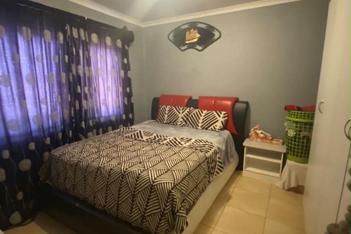 A standard bedroom featuring tiled flooring, a built-in wardrobe, and cove cornice detailing.