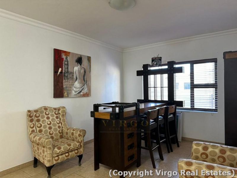 A living area featuring tiled flooring and a window with fitted blinds, providing a neutral space ready for personalization.