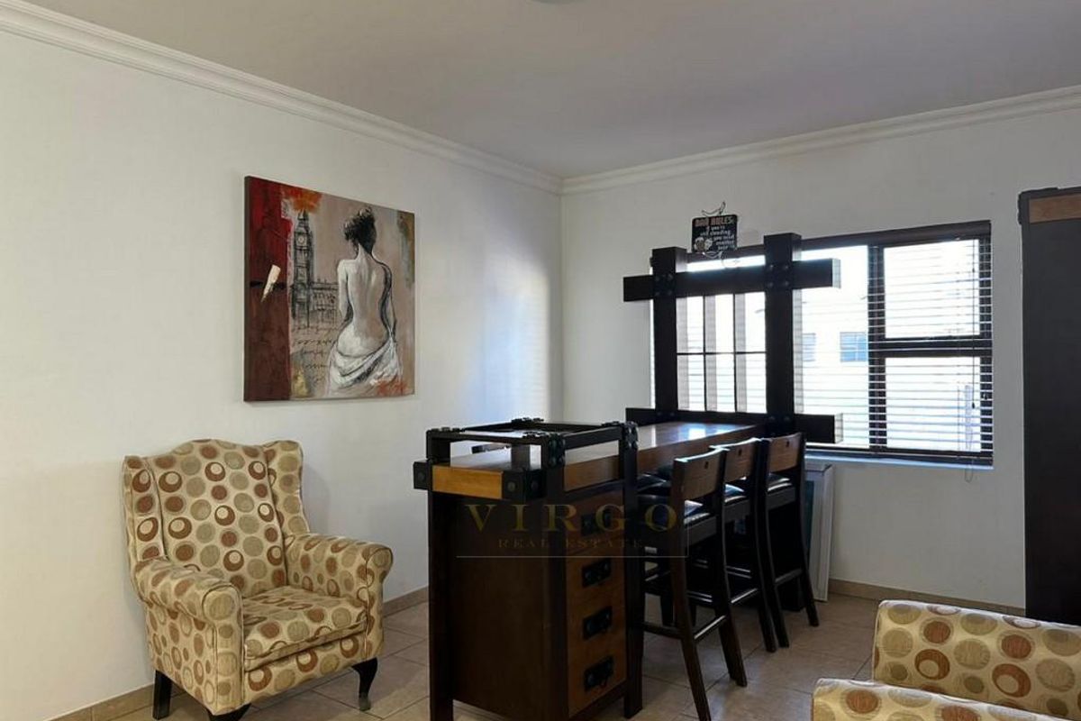 A living area featuring tiled flooring and a window with fitted blinds, providing a neutral space ready for personalization.