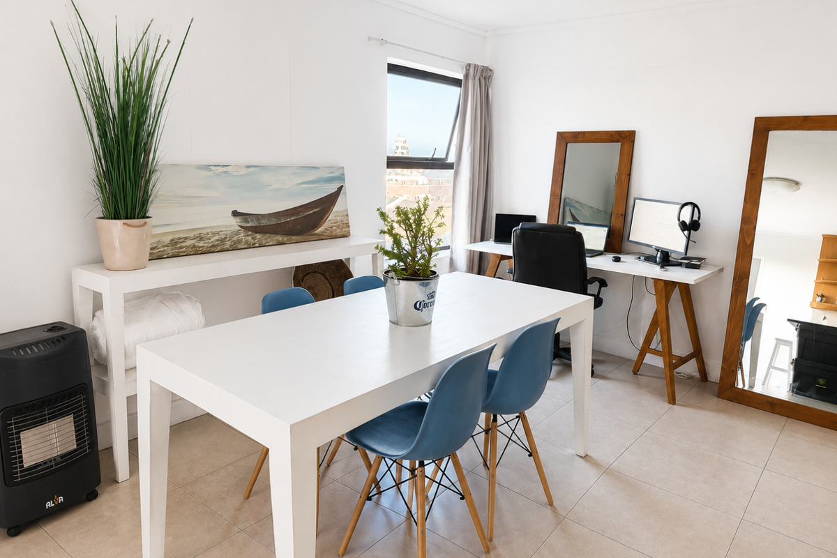 A bright, open-plan living area featuring neutral tiled flooring and a large window providing natural light and an exterior view.