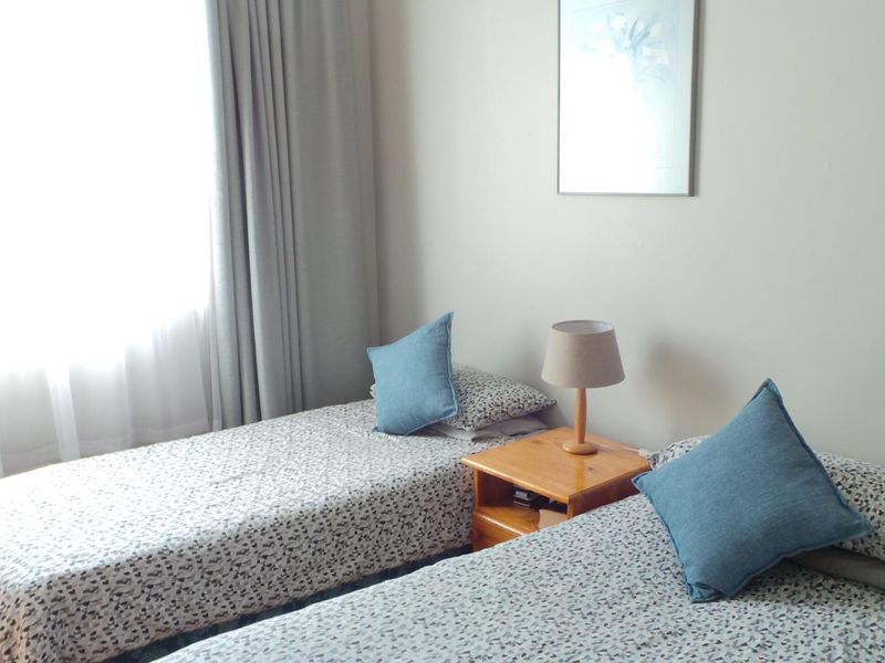 A bedroom featuring timber flooring and neutral wall finishes, providing a comfortable and functional sleeping space.