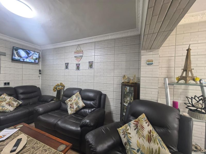 A living room featuring white brick-style wall cladding and decorative ceiling cornicing, providing a textured finish to the space.