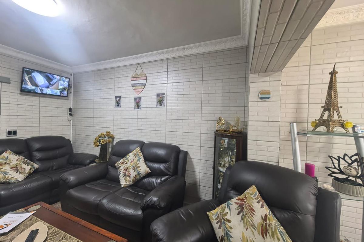A living room featuring white brick-style wall cladding and decorative ceiling cornicing, providing a textured finish to the space.