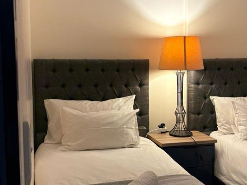 A bedroom featuring a neutral color palette with a focus on sleeping space.