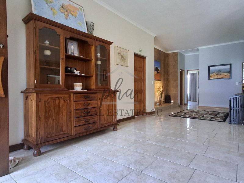 Spacious living area featuring neutral tiled flooring and a stone-clad feature wall, providing a versatile layout for comfortable family living.