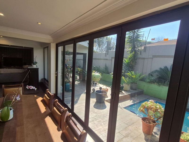 Open plan living area featuring large stacking glass doors that provide seamless indoor-outdoor flow to the patio and swimming pool area.