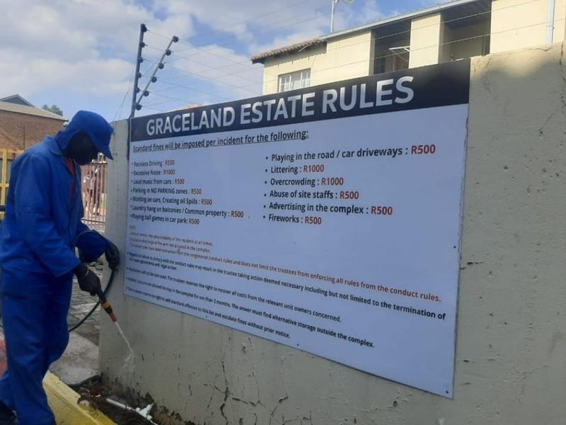 A view of the estate boundary wall featuring the complex rules and signage at the entrance.